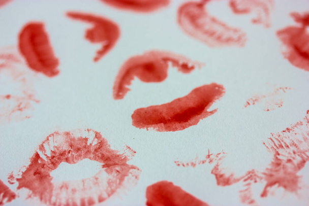 Set van sexy roze rode vrouwelijke lip prints op witte papieren achtergrond bovenaanzicht. Kust plat. Vingerafdrukken van lippenstift. Vrouwelijkheid, flirten, liefdesconcept. Wereldkus Dag. Valentijnsdag. Mooie achtergrond. - Foto, afbeelding