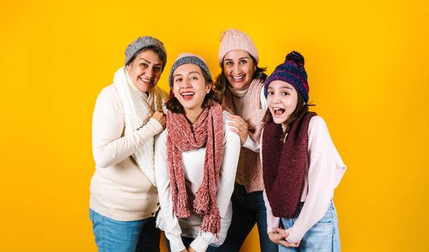 Зимний портрет счастливой латинской семьи Три поколения латиноамериканских женщин на желтом фоне в Мексике Латинская Америка - Фото, изображение