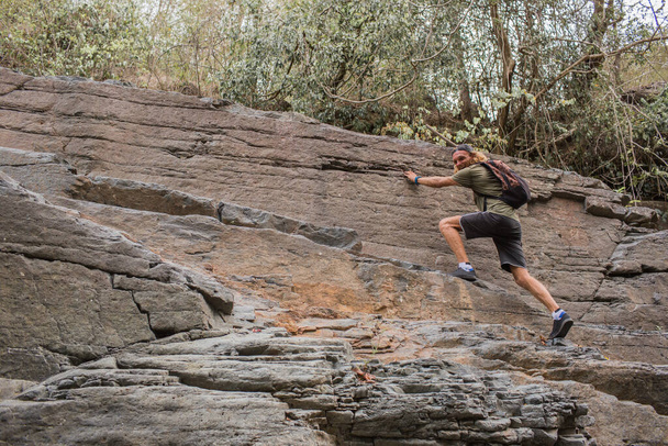 local tourism. Guy climbs on the rocks - Zdjęcie, obraz