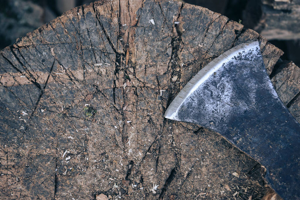 Um machado velho com uma alça de madeira está em uma pilha de lenha, vista superior de perto - Foto, Imagem