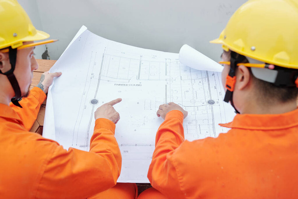 Builders Pointing at Blueprint - Photo, Image
