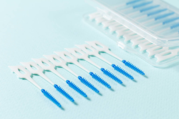 Close-up interdental brushes with a plastic box on the blue background. Shallow depth of field. - Foto, afbeelding