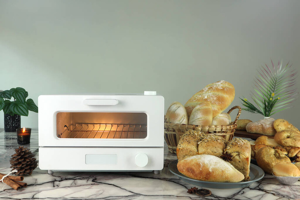 https://cdn.create.vista.com/api/media/small/527444540/stock-photo-white-modern-design-toaster-oven-table-homemade-toast-breads-grey