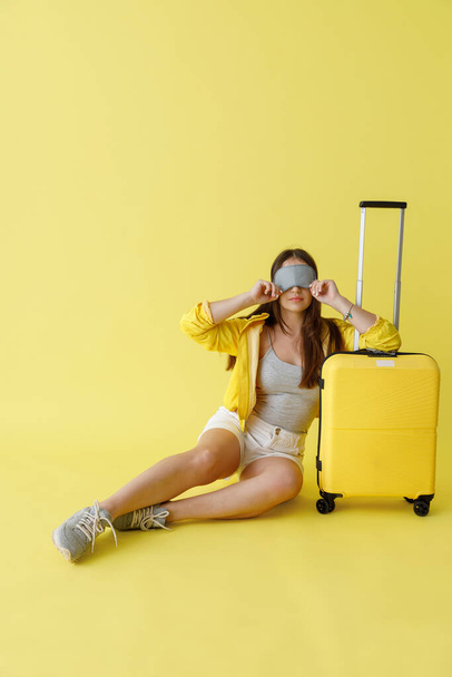 Elbűvölő álarcos nő ül közel utazási táska - Fotó, kép