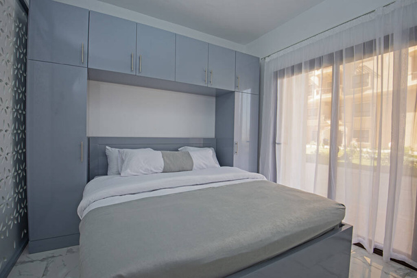 Interieur inrichting inrichting van luxe show home slaapkamer met meubilair en een tweepersoonsbed - Foto, afbeelding