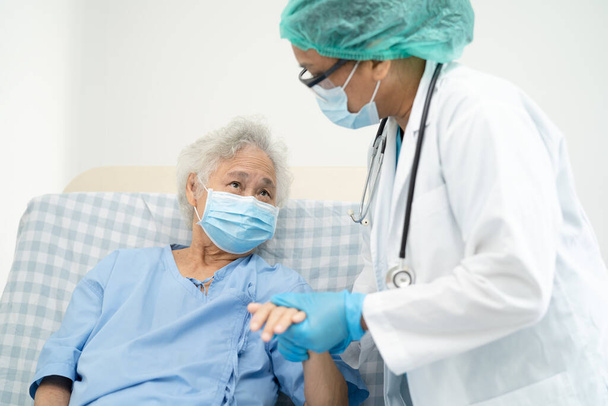 医師のヘルプアジアの高齢女性高齢者や高齢者の女性患者は、安全感染を保護し、 Covid-19コロナウイルスを殺すために病院で顔マスクを着用. - 写真・画像