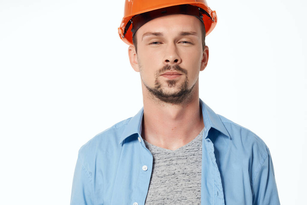 Männlicher Bauarbeiter im blauen Hemd posiert professionell im Studio - Foto, Bild