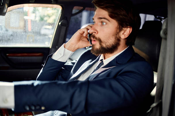 emotional man in a suit in a car a trip to work success service rich - Foto, Imagem