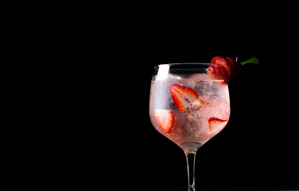 A closeup shot of a strawberry alcoholic cocktail on a dark background - Photo, Image