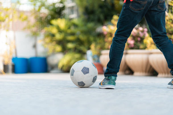 A Closeup of a soccer ball and a kid playing outdoors - Φωτογραφία, εικόνα