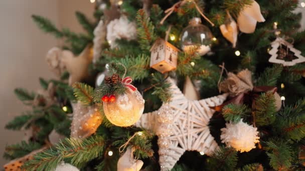 Schön geschmückter Weihnachtsbaum in Nahaufnahme in leuchtenden Lichtern aus einer Girlande.  - Filmmaterial, Video