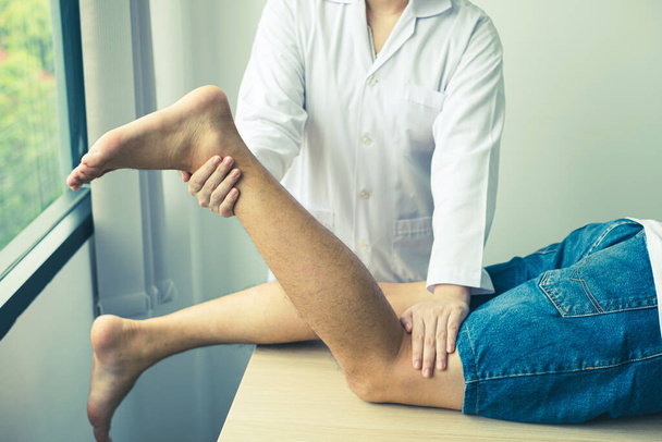 Männliche Patienten wandten sich zur Untersuchung und Behandlung an Physiotherapeuten mit Knieschmerzen. Reha-Physiotherapiekonzept. - Foto, Bild