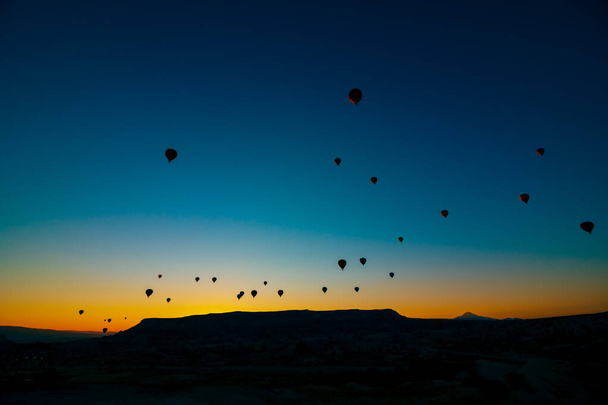 Hot air balloons. Silhouette of hot air balloons at sunrise in Cappadocia. Cappadocia activities or tourism in Turkey background photo. - Фото, изображение