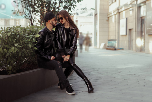 handsome young couple in love looks at each others on the bench in the city - Фото, зображення