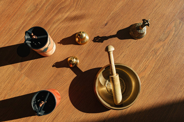 Tibetan singing bowls, bells, for meditation and relaxation on wooden floor. Hamdmade percussion music instruments. Sound massage and healng. - Foto, immagini
