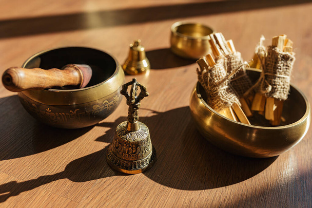 Tibetische Klangschalen, Glocken, zum Meditieren und Entspannen auf Holzboden. Palo Santo Räucherwälder aus nächster Nähe. Klangvolle Massage und Heilung. - Foto, Bild