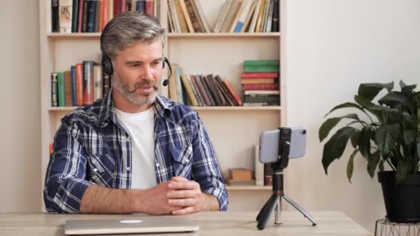 成人男性vloggerは、スマートフォンアプリを使用してライブビデオ会議電話をオンラインにする. - 映像、動画