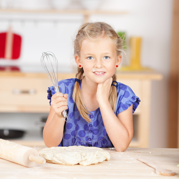 Little girl holding wire whisk with dough - Foto, imagen