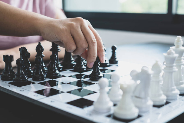 Die Hand der Geschäftsfrau bewegt sich, Schach im Wettbewerb zeigt Führung, Anhänger und Strategien für geschäftlichen Erfolg. - Foto, Bild