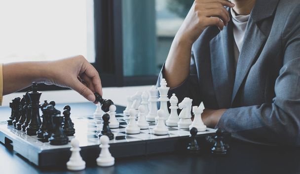 De handen van zakenvrouwen twee mensen die schaken in schaakcompetities demonstreren leiderschap, volgers, en strategische plannen, business success building processen, en teamwork. - Foto, afbeelding