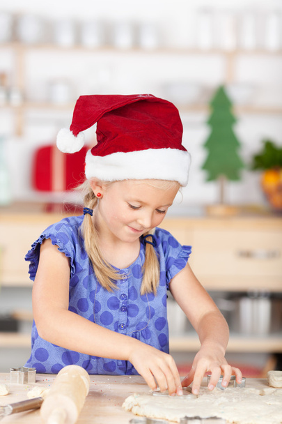 Girl with santas hat baking cookies - Фото, изображение