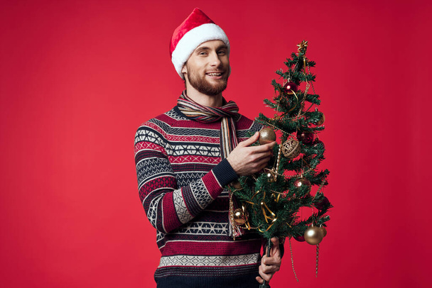Noel Baba şapkalı duygusal adam Noel süslemeleri Noel tatili kırmızı arka plan - Fotoğraf, Görsel
