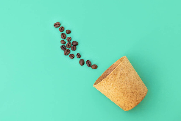 Vue du dessus de la tasse à gaufres avec des grains de café sur fond vert. Zéro déchet - Photo, image