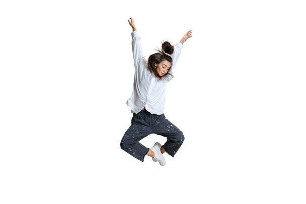 One pretty woman in casual wear jumping, flying isolated on white background. Art, motion, action, flexibility, inspiration concept. - Valokuva, kuva