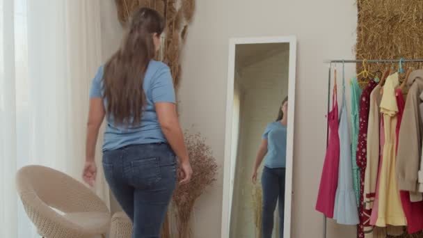 Pullea nainen katselee pohdintaa, tarkistaa rasvaa kertaiseksi vatsa sisätiloissa - Materiaali, video