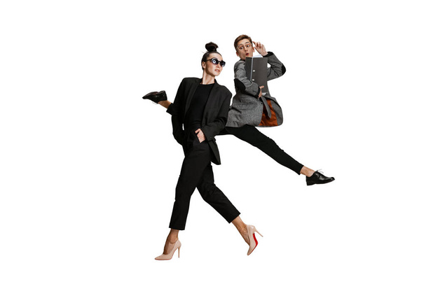 Dva stylové kancelářské pracovníky v obchodních oblecích v akci izolované na bílém pozadí. Umění, krása, móda a obchodní koncepce - Fotografie, Obrázek