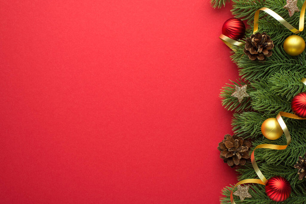 Top view kuva kulta ja punainen joulukuusi pallot mänty käpyjä hehkuva tähteä ja kulta kiemurteleva männyn oksat eristetty punainen tausta tyhjä tila - Valokuva, kuva