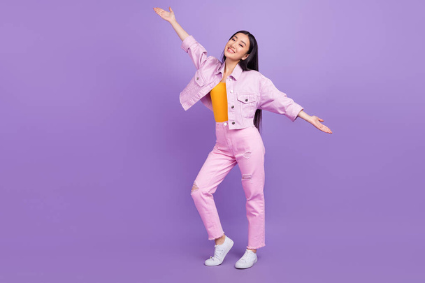 Full length photo of funky young brunette lady wear jacket jeans sneakers isolated on violet background. - Foto, imagen