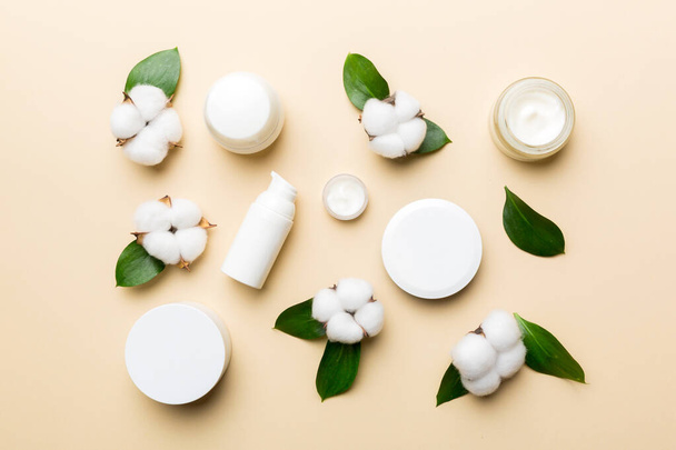 Produtos cosméticos orgânicos com flor de algodão e folhas verdes em fundo de madeira. Depósito plano. - Foto, Imagem