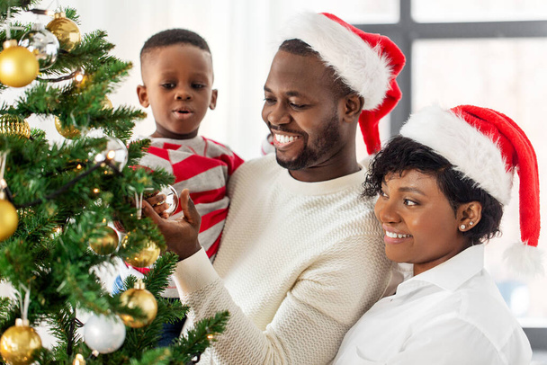 happy family decorating christmas tree at home - Fotó, kép