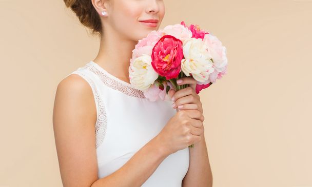 smiling woman in white dress with bouquet of roses - 写真・画像