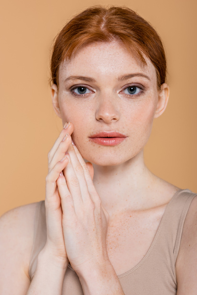 Young redhead woman with perfect skin looking at camera isolated on beige  - Foto, Bild