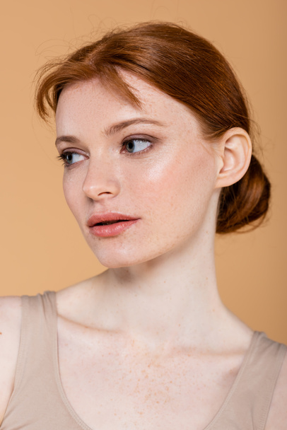 Portrait of redhead woman with clean skin looking away isolated on beige  - Foto, Imagem