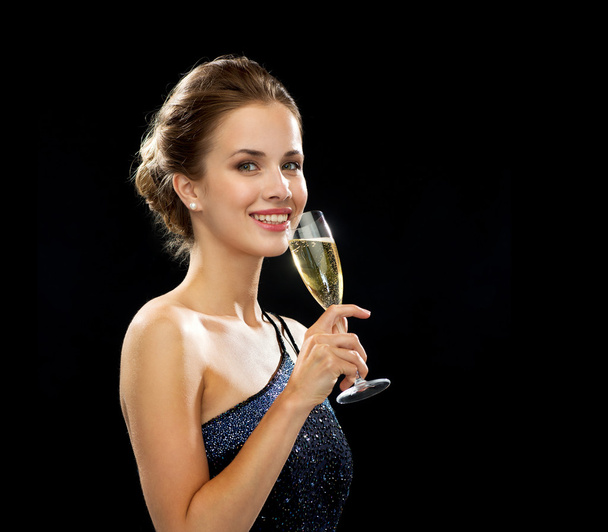 smiling woman holding glass of sparkling wine - Foto, imagen