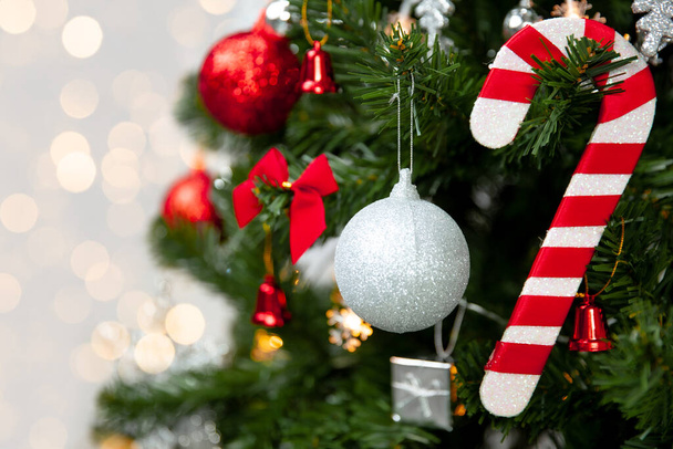 Arbre de Noël avec décoration rouge et canne à bonbons sur fond de lumière dorée floue - Photo, image