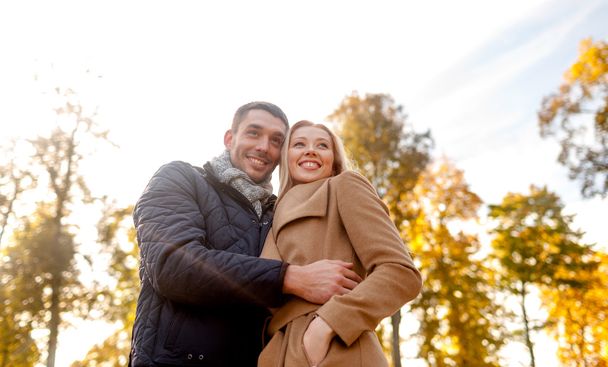 smiling couple hugging in autumn park - 写真・画像