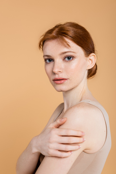 Redhead woman with perfect skin looking at camera isolated on beige  - Φωτογραφία, εικόνα