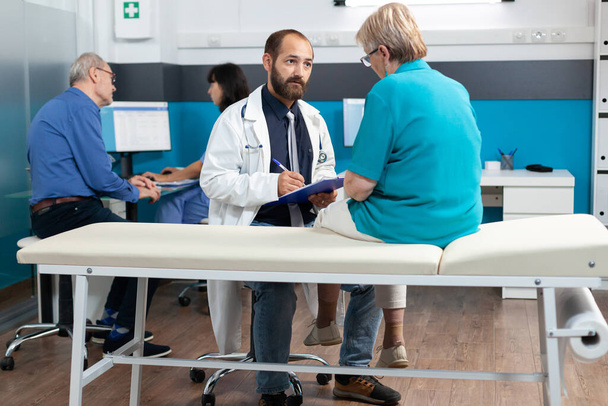 Starší pacient diskutující s lékařem o osteopatii - Fotografie, Obrázek