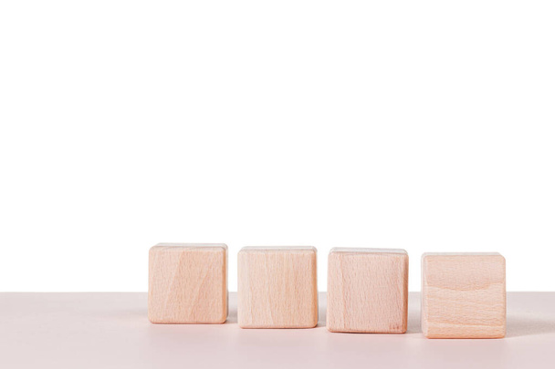 Чотири дерев'яні кубики на білому тлі крупним планом
 - Фото, зображення