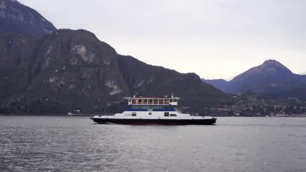 Ferry drijft op het meer tegen de achtergrond van bergen. Como, Italië - Video