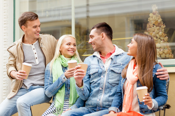 group of smiling friends with take away coffee - Foto, Bild