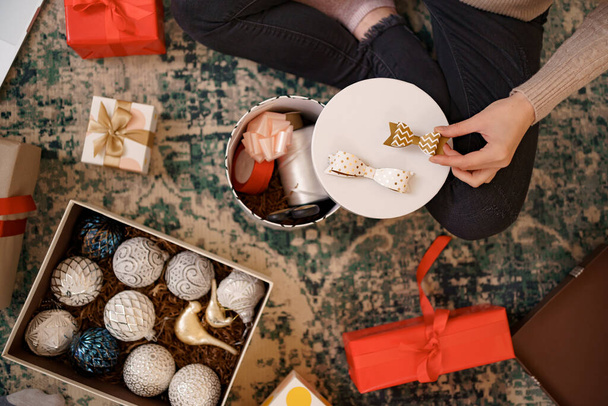 Woman wrapping Christmas gifts presents at home - Valokuva, kuva