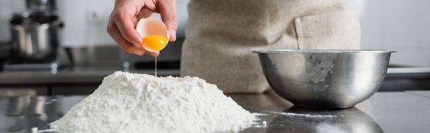 Обрізаний вид шеф-кухаря, що поливає яєчний жовток на борошно на столі, банер
  - Фото, зображення