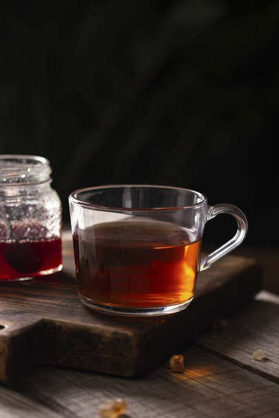 Cup of black tea on a wooden table - Valokuva, kuva