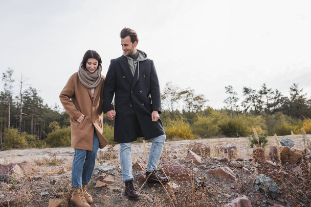 jovem casal em roupa de outono de mãos dadas enquanto caminhava ao ar livre - Foto, Imagem