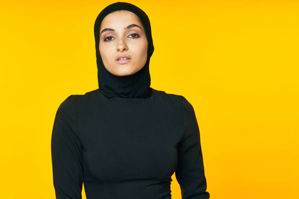 pretty woman muslim black hijab yellow background - Foto, immagini